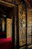 Wat Xieng Thong temple in Luang Prabang, Laos. The facade of the sim decorated with gold stencilling on a black lacquer background. 